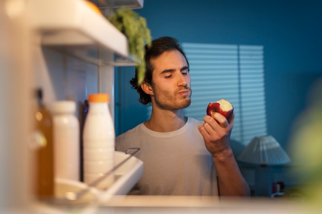 Foto gratuita uomo di vista frontale che mangia mela