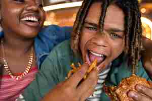 Free photo front view man eating burger in a funny way