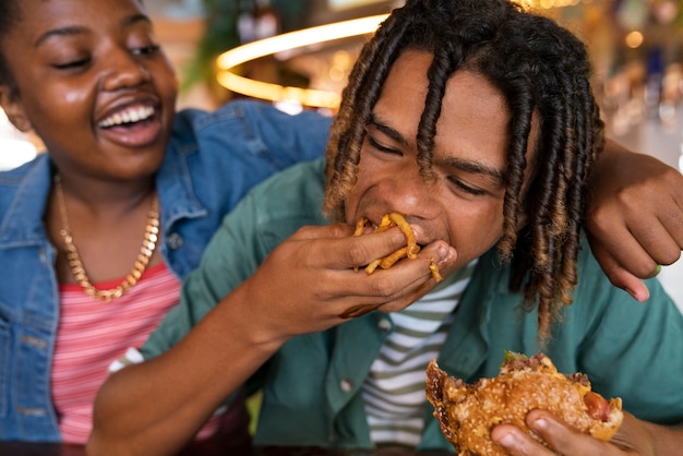 Foto gratuita hamburger mangiatore di uomini di vista frontale in un modo divertente