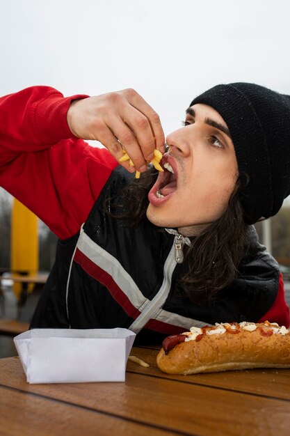 無料写真 フライドポテトを食べる正面の男