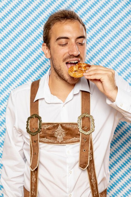 ドイツのプレッツェルを食べている男の正面図