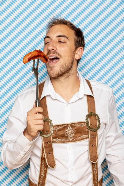 Front view of man eating german sausage