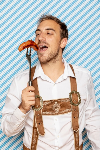 Вид спереди человек ест немецкую колбасу