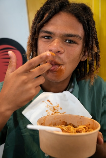 Free photo front view man eating pasta in a funny way