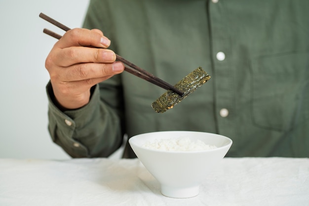 箸で食べる正面男