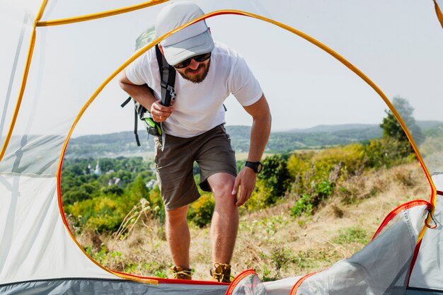 Front view man entering tent 