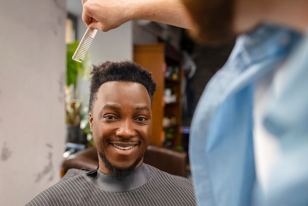 Foto gratuita uomo di vista frontale ottenendo un taglio di capelli