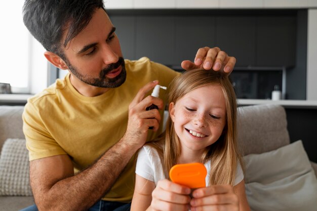 Front view man helping girl with lice