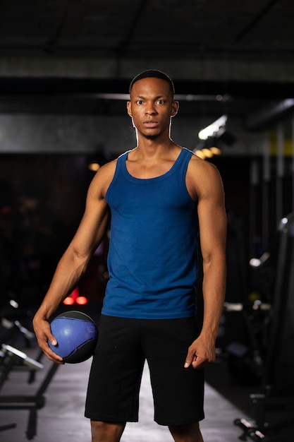 Front view man holding ball at gym