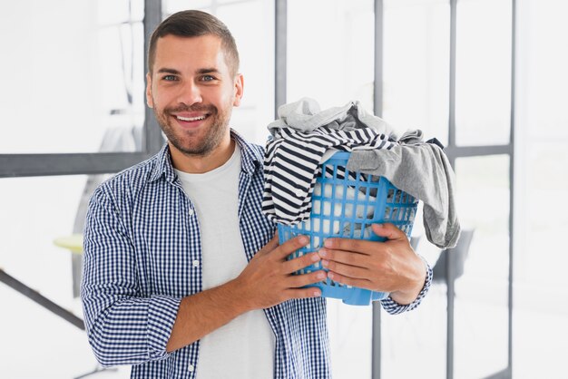 Front view man holding basket with clothes