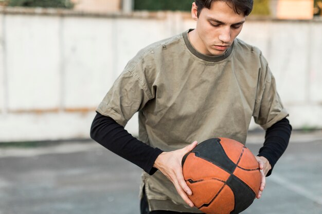 Front view man holding a basketball