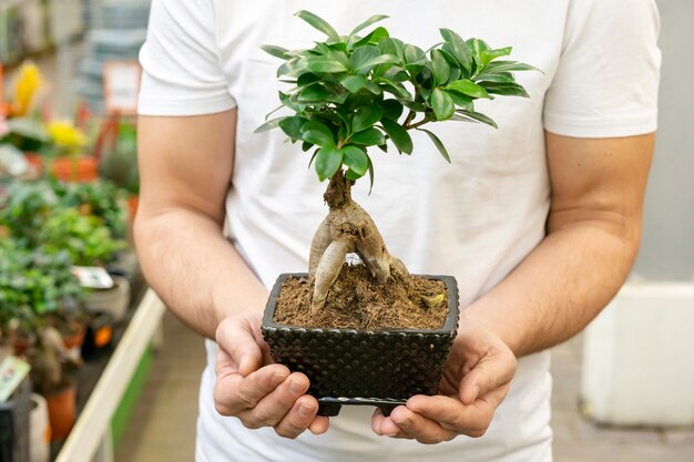 美しい観葉植物を保持している正面図男