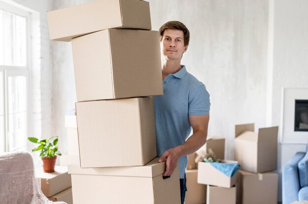 Front view of man holding boxes for moving out