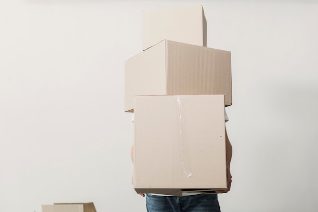 Front view man holding carton boxes