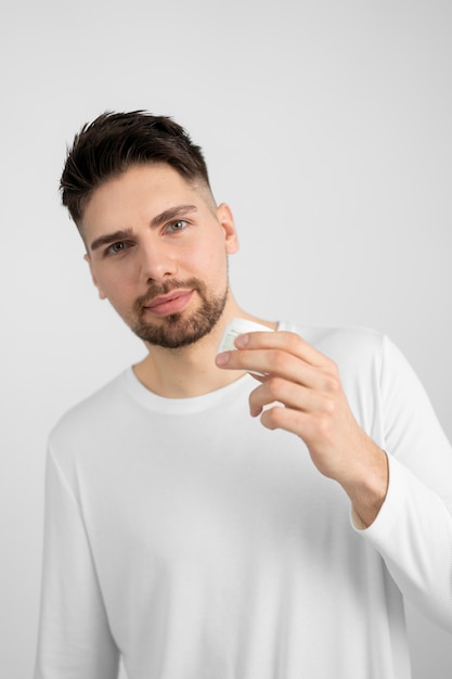 Front view man holding cream container