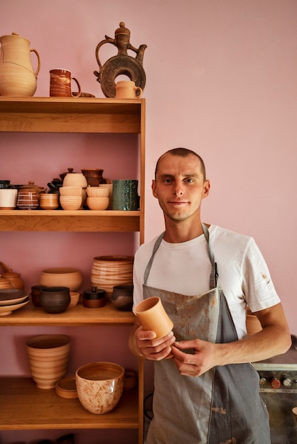 Foto gratuita tazza della holding dell'uomo di vista frontale