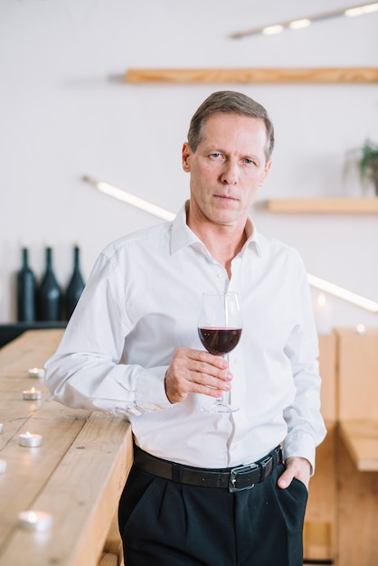 Free photo front view of man holding glass of wine