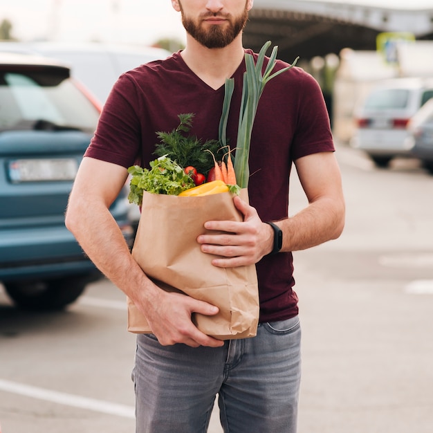 Front view man holding grocery bag