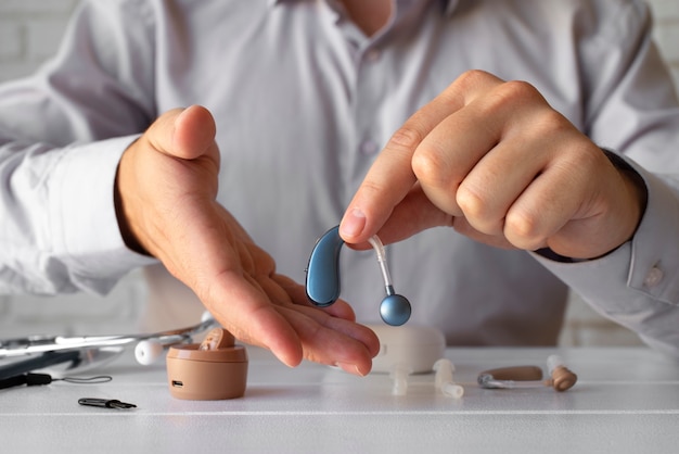 Front view man holding hearing aids