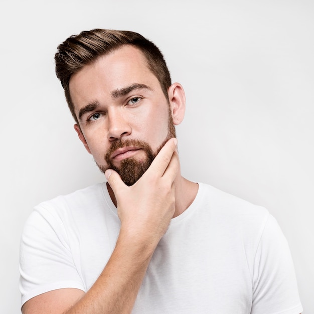 Front view man holding his beard