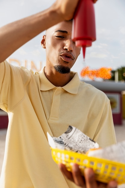 Free photo front view man holding ketchup