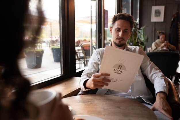 Front view man holding menu