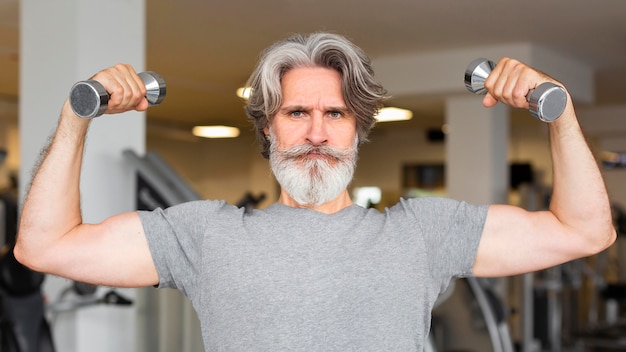 Front view man holding metal dumbbells