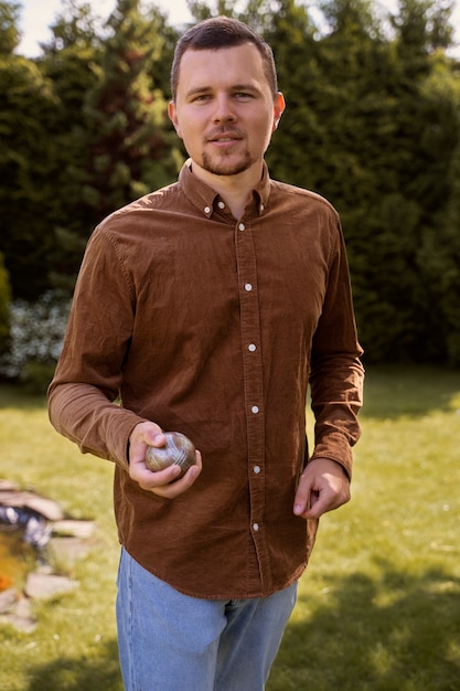 Front view man holding metallic ball