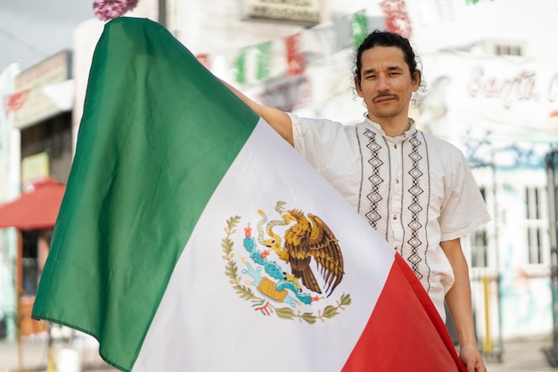 Вид спереди мужчина держит мексиканский флаг
