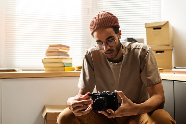 Free photo front view man holding photo camera