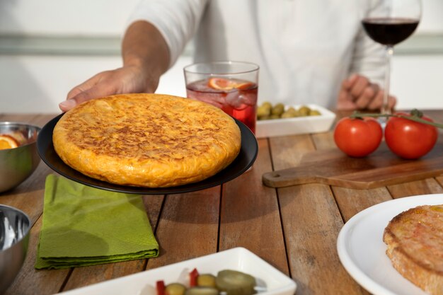 Front view man holding plate with spanish tortilla