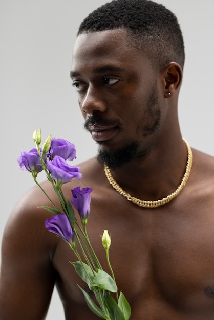 Вид спереди мужчина держит фиолетовый цветок