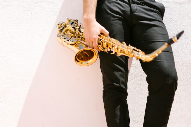Free photo front view of man holding saxophone