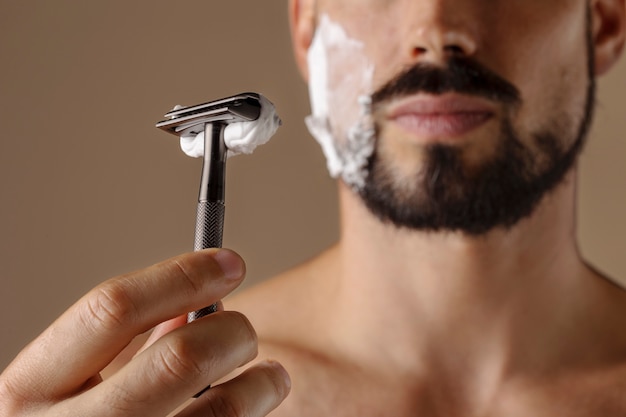 Front view man holding shaving razor