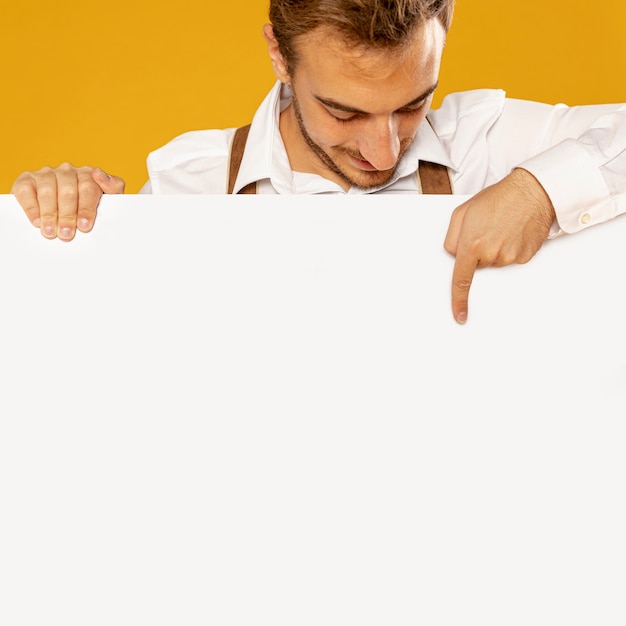 Free photo front view of man holding sign mock-up