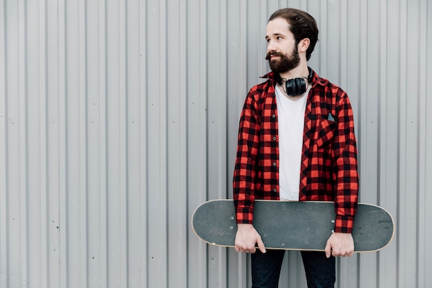 Front view of man holding skateboard