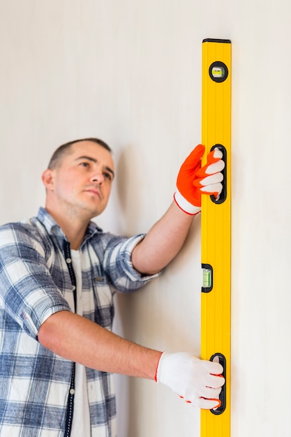 Front view of man holding spirit level