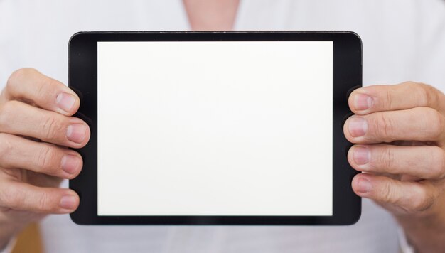 Front view man holding a tablet close-up