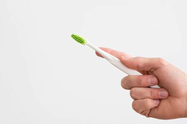 Free photo front view of man holding toothbrush with copy space