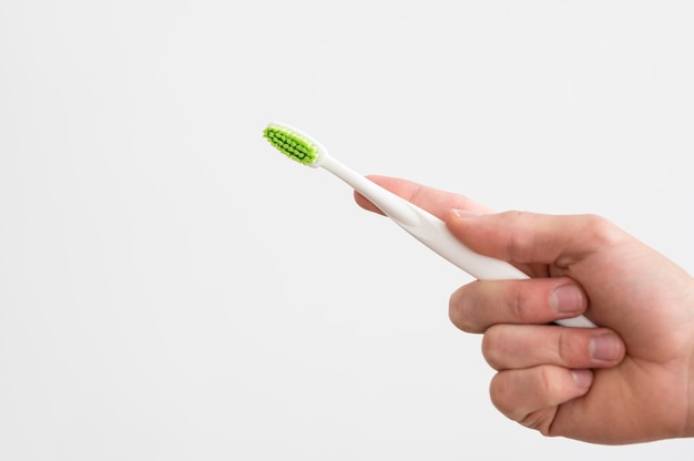 Front view of man holding toothbrush with copy space