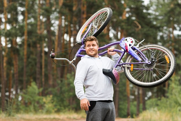 Вид спереди мужчина держит велосипед