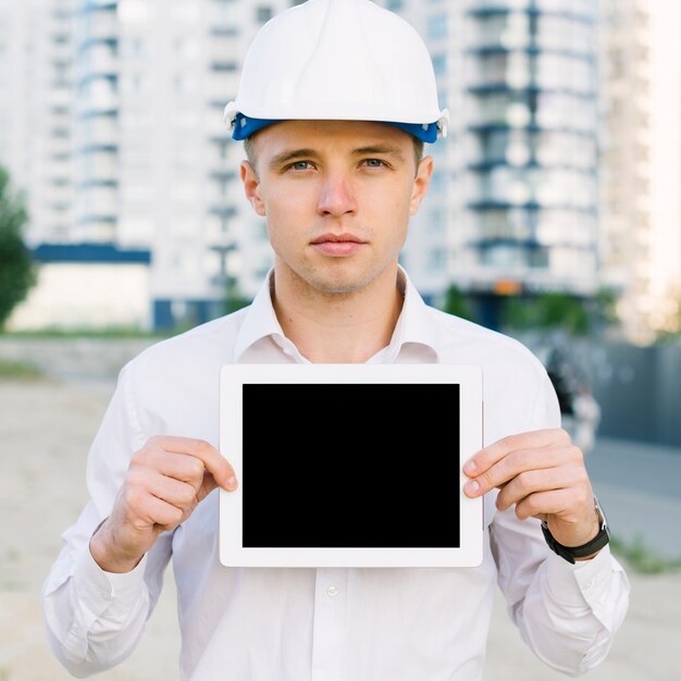 Front view man holding up tablet