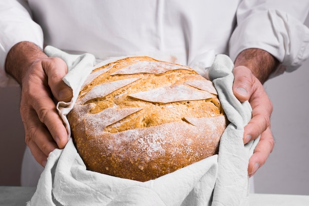 Foto gratuita uomo di vista frontale che tiene un pane avvolto