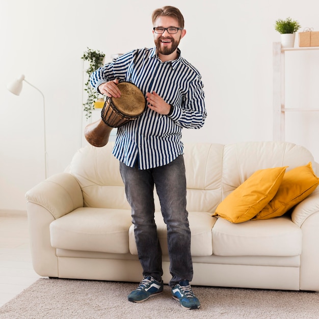 Front view of man at home with drum