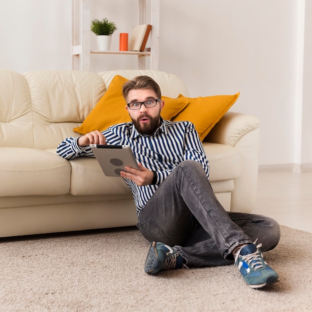 Free photo front view of man at home with tablet