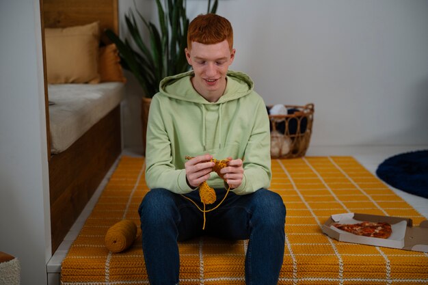 Free photo front view man knitting at home