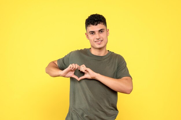 Front view of the man makes a heart with his fingers