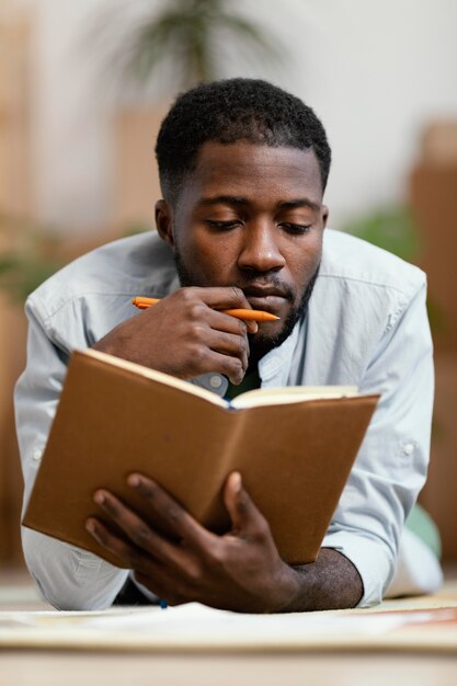 Front view of man making plans to redecorate home on the floor