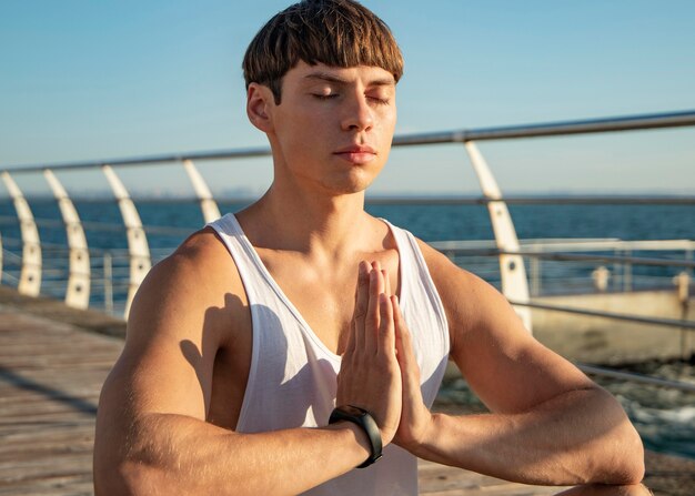 Вид спереди человека, медитирующего на пляже
