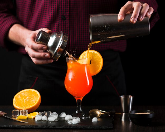 Front view of man mixing cocktail